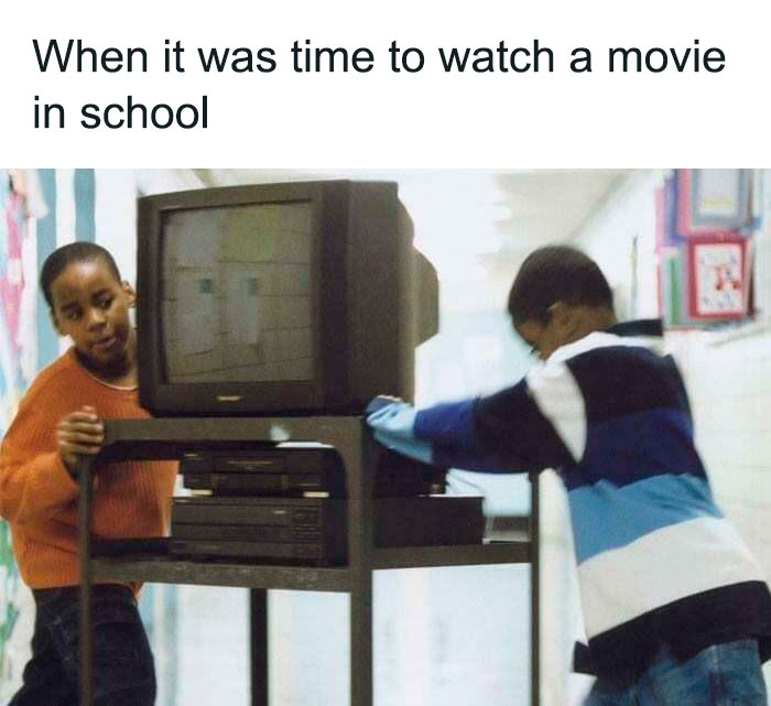Kids pushing a TV on a cart in school, capturing the essence of '90s nostalgia.