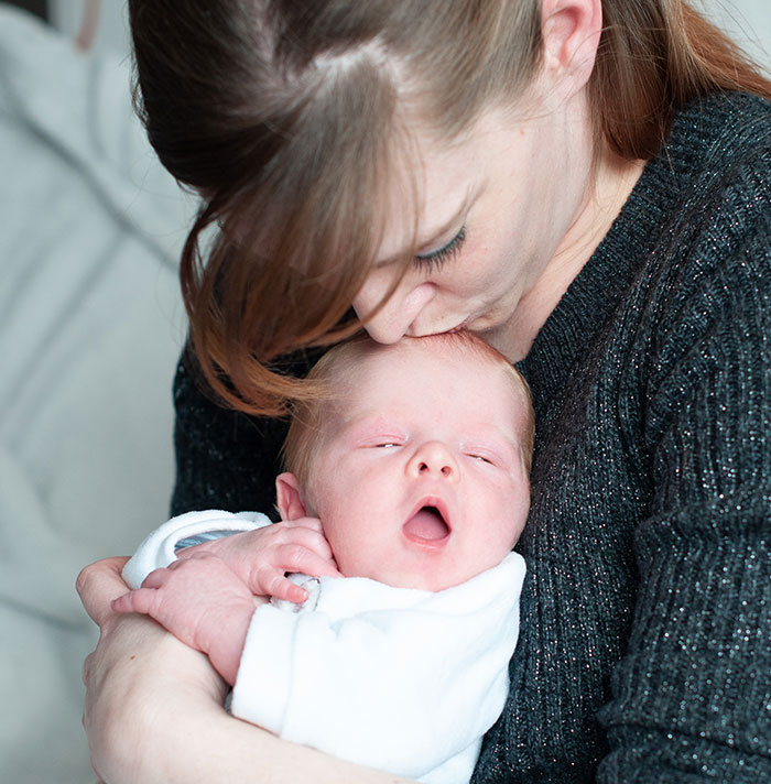 A mother lovingly holds her newborn baby, showcasing the bond between parent and child.