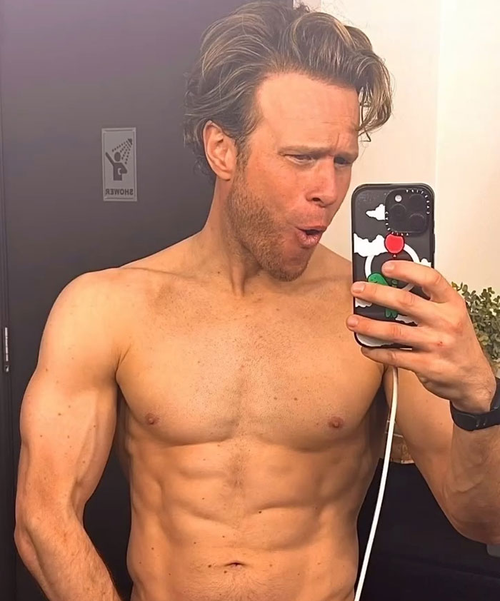 Shirtless singer showing physique transformation in a mirror selfie, sparking debate among men and women.