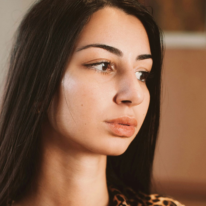 Woman with long dark hair looking contemplative, associated with out-of-touch statements.