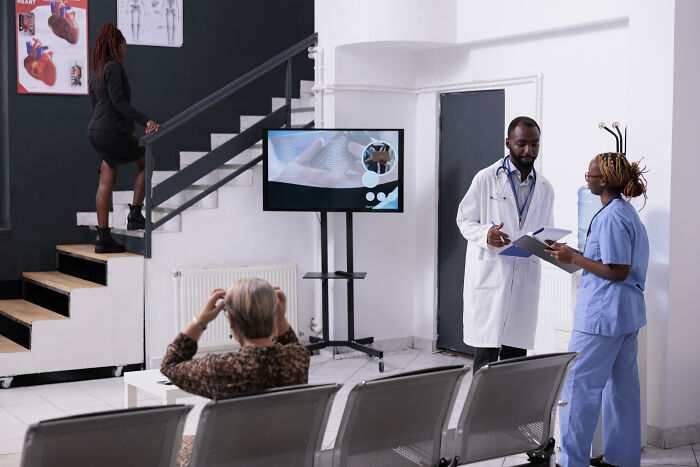 Medical staff discussing notes in a waiting room as patient waits, illustrating usual things changed by the pandemic forever.