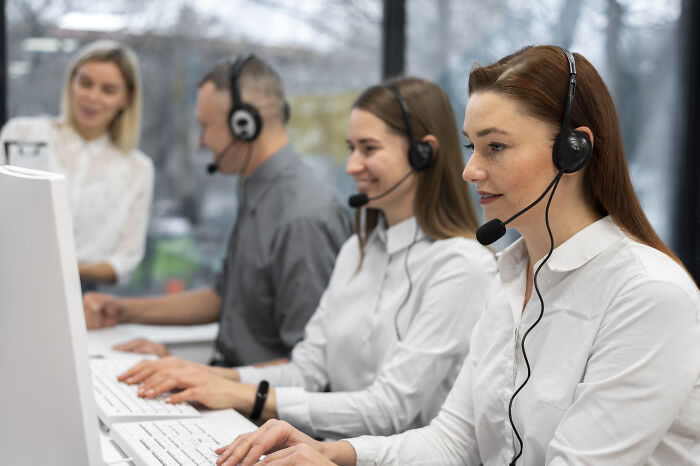 Customer support team wearing headsets working at computers, illustrating usual things changed by the pandemic.