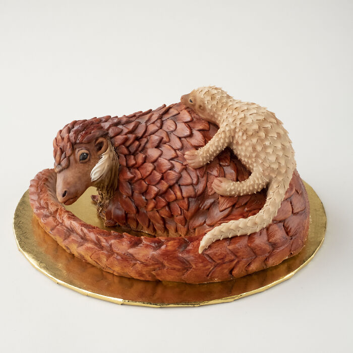 Vegan cake shaped like a pangolin, featuring detailed scales and a baby on its back.