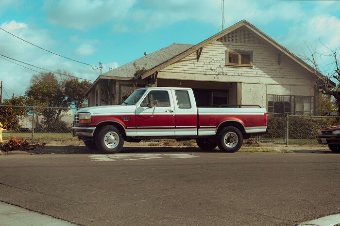 Red and white truck appears elevated above the street, creating a glitch in the Matrix illusion.