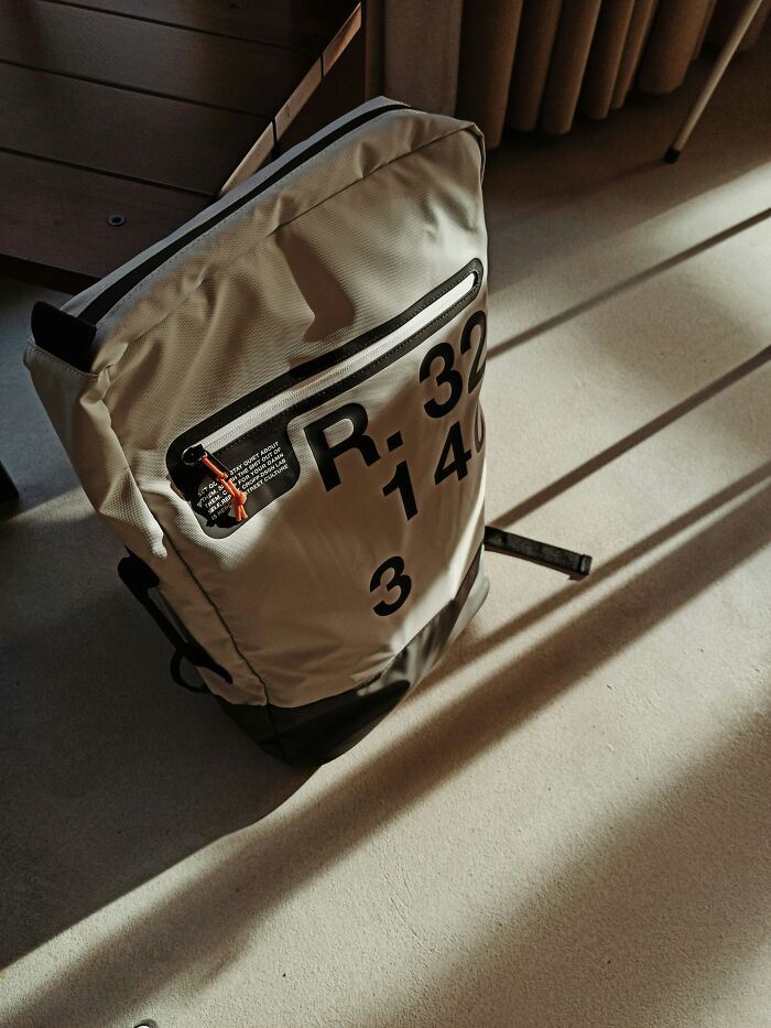 Backpack with numbers resembling a glitch in the Matrix, casting long shadows on the floor.
