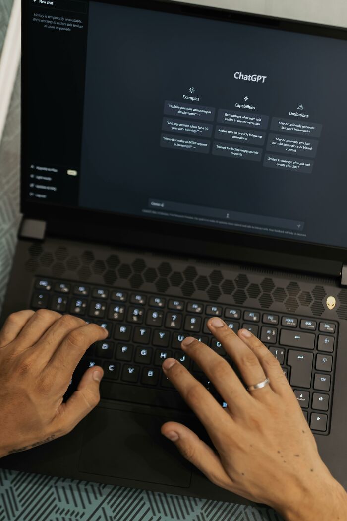 Hands typing on a laptop running ChatGPT, illustrating creative ways to use AI technology.