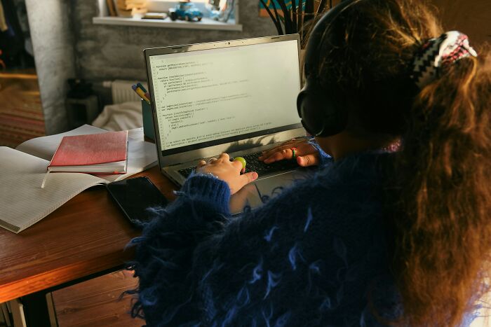 Person using laptop with code on screen, illustrating ways to interact with ChatGPT.