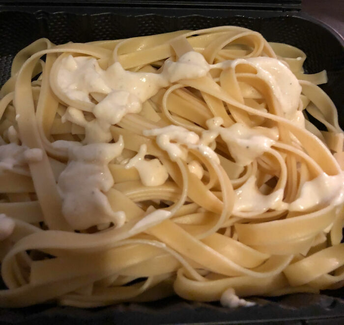 Pasta dish in a takeout container with creamy sauce, representing items some people avoid.