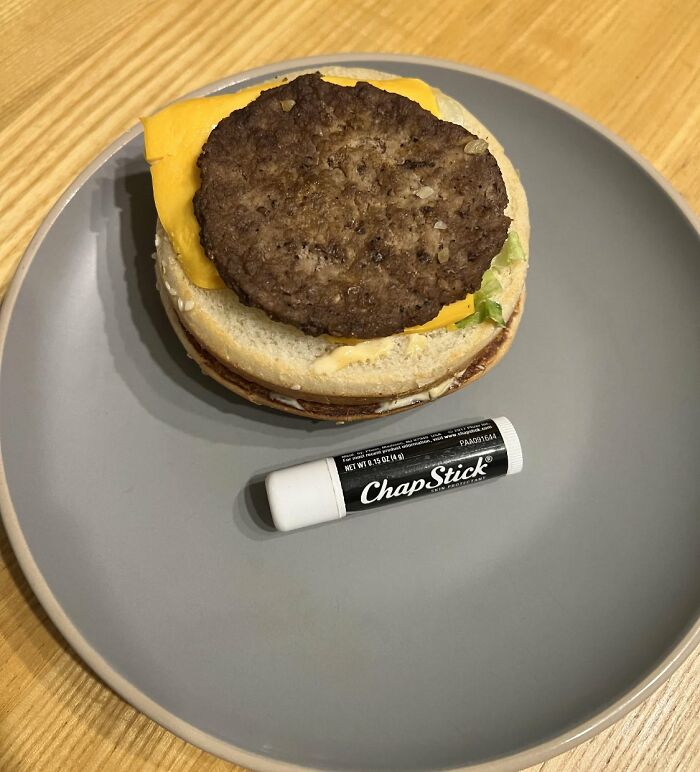 Burger with cheese on a plate next to a ChapStick, highlighting refrained items and brands.
