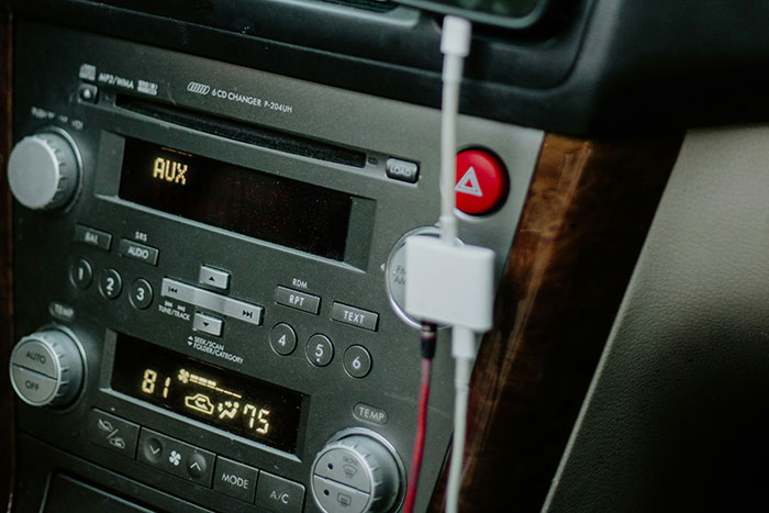 Car stereo system displaying AUX input, reflecting boomers' preference for traditional tech in vehicles.