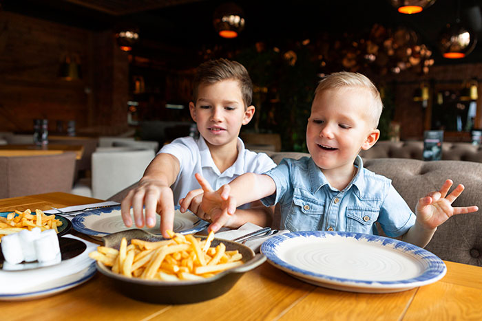 Two young children enjoying fries at a restaurant, representing perspectives on things boomers might be right about.