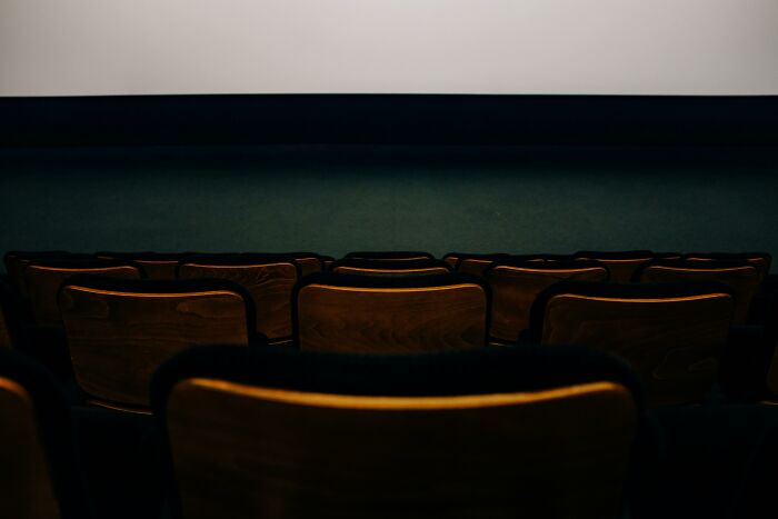 Empty movie theater with rows of seats facing a blank screen, ready for viewers to recognize characters.