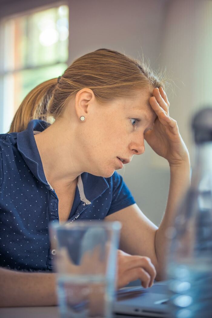 A person pondering at a desk, reflecting on Americans moving abroad permanently.