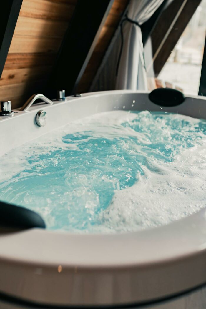 Luxurious vessel sink bathtub with bubbling water, stylish yet impractical for home use.