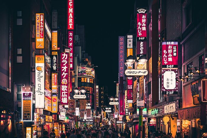 Vibrant city street with bright neon signs, symbolizing an experience of Americans moving abroad permanently.