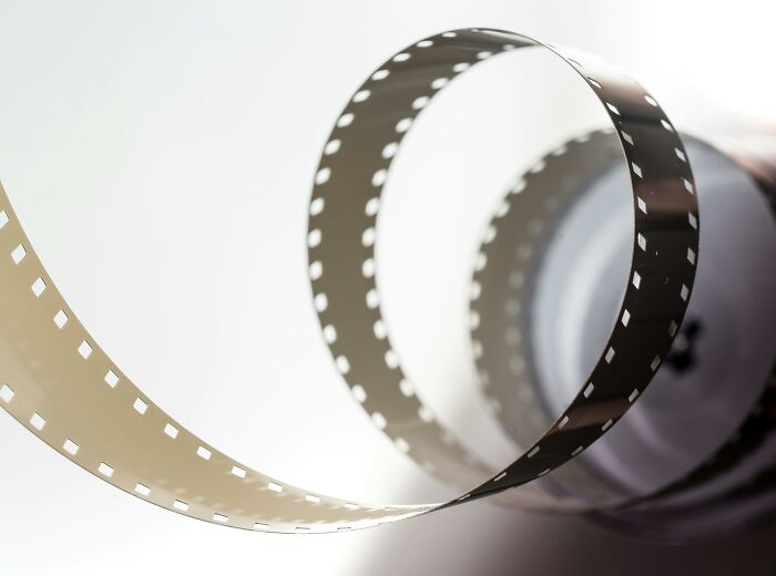 A rolled strip of film representing iconic movie moments.
