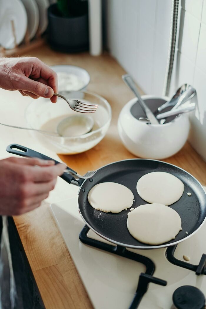 Person cooking pancakes in a kitchen, illustrating obvious things you've just become aware of in daily life.