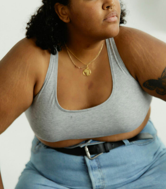 Woman in a grey tank top and jeans, representing common insecurities women feel that often confuse men.