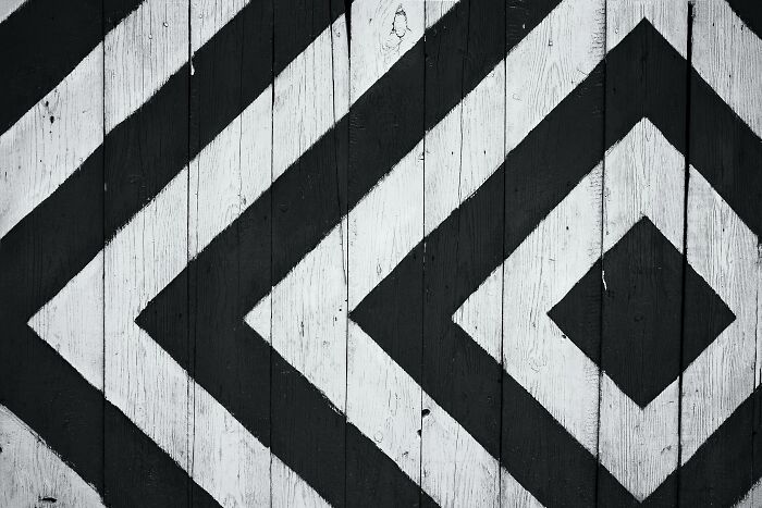 Black and white geometric symbols painted on wooden planks, representing everyday symbols and their hidden meaning.