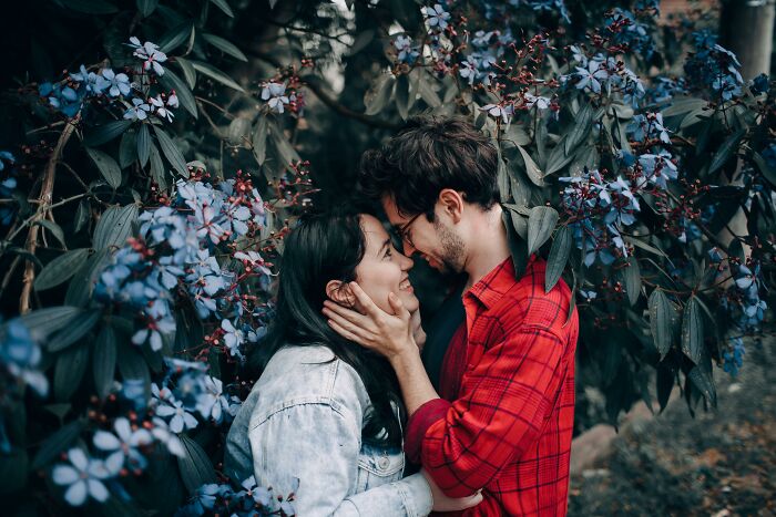 Couple in an intimate moment surrounded by flowers, illustrating emotional connection beyond church-related experiences.