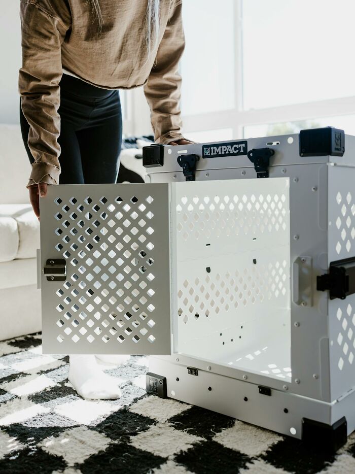 Person opening a white crate inside a house, showcasing unusual interior decor.