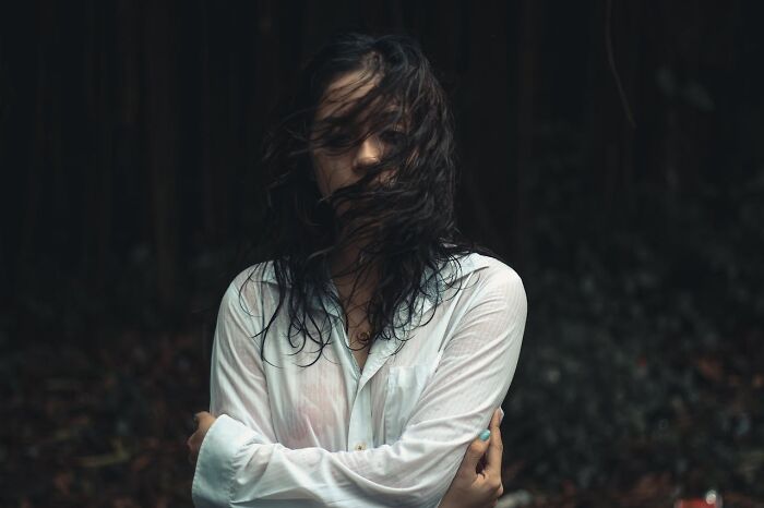 Woman with wet hair and white shirt in a dark outdoor setting, evoking emotions tied to first responders' memorable calls.
