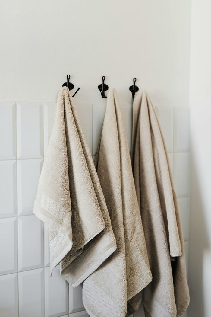 Towels neatly hanging on hooks, illustrating cleaning rules preferences.