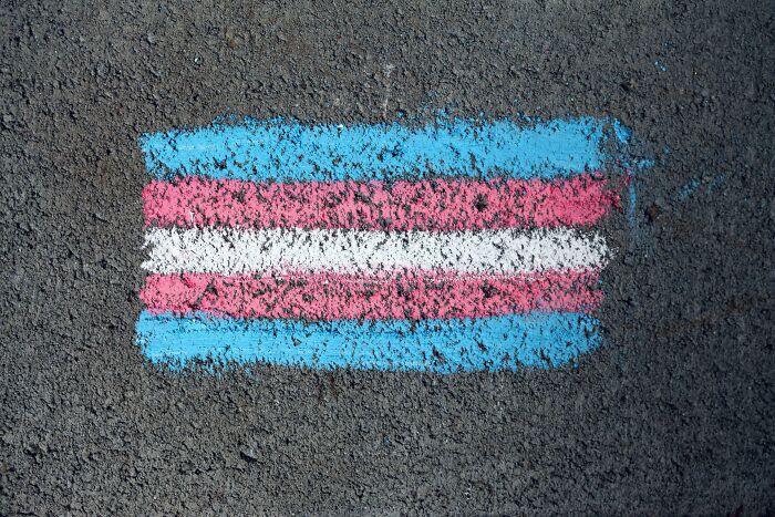 Chalk-drawn transgender flag on concrete resonates with reasons from a viral online thread about church attendance decline.