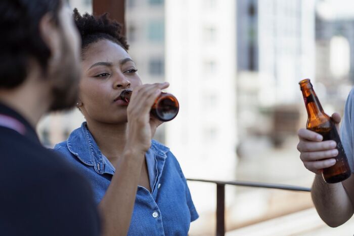 People on a rooftop, each holding a beer, socializing and trusting their gut instincts.