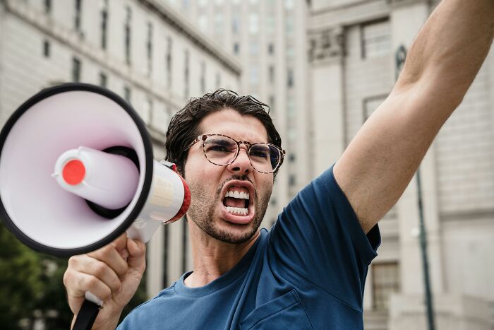 A passionate man with glasses and a megaphone, symbolizing unique American expressions.