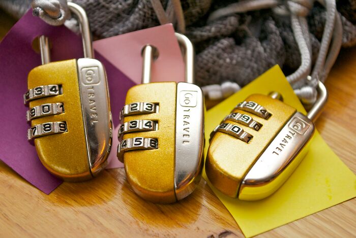 Three gold combination locks on colored tags, illustrating security concepts.