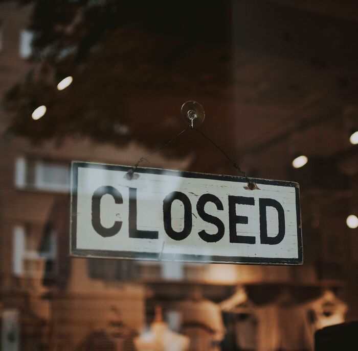 Closed sign hanging on a shop window symbolizing unfortunate stories of lottery winners facing unexpected challenges.