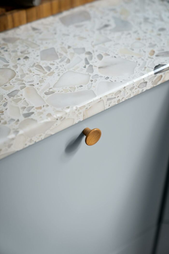 Terrazzo countertop over blue cabinet, showcasing design yet impracticality in home settings.