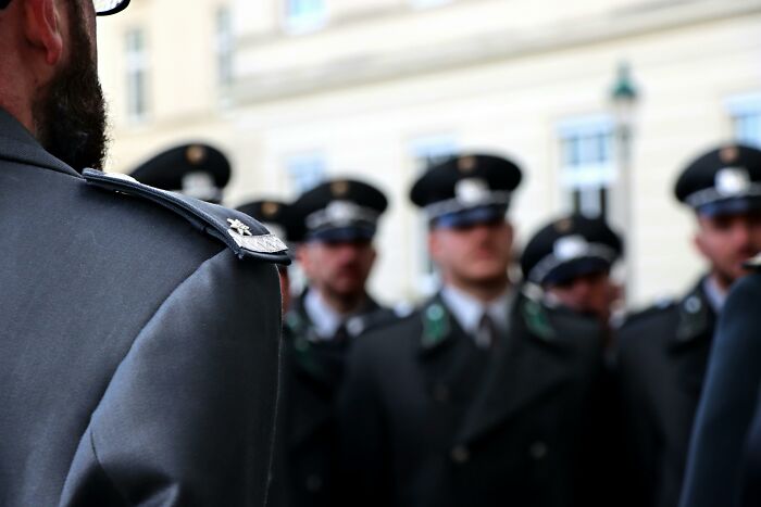 Uniformed officers in a formal gathering, with focus on badge details.