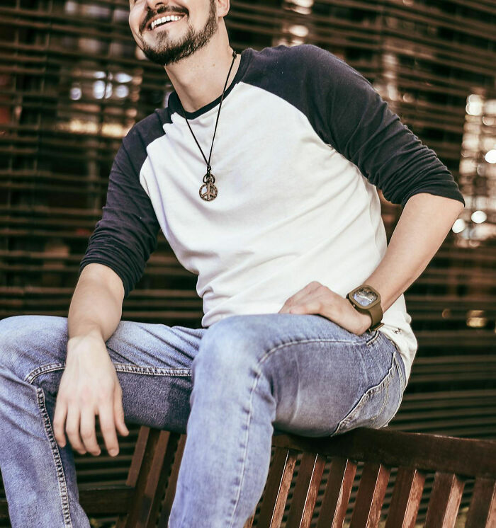 Casually dressed man sitting, reflecting on living abroad as an American.