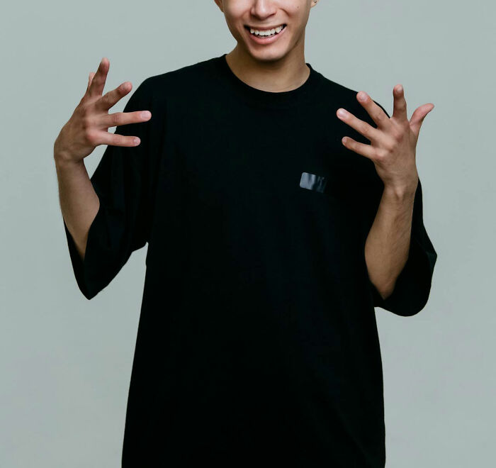 A person in a black shirt smiling with open hands, discussing disturbing medical cases.