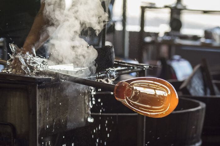 Glassblowing process with hot molten glass, showcasing a professional skill often unknown to the general public.