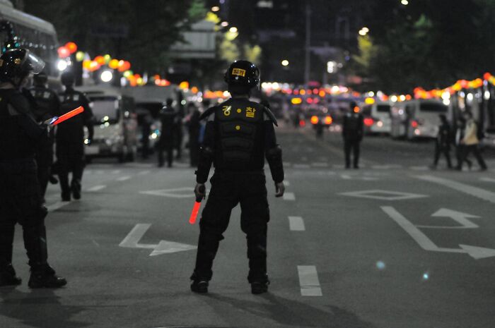 Police officers securing a city street at night, ensuring safety during an event.