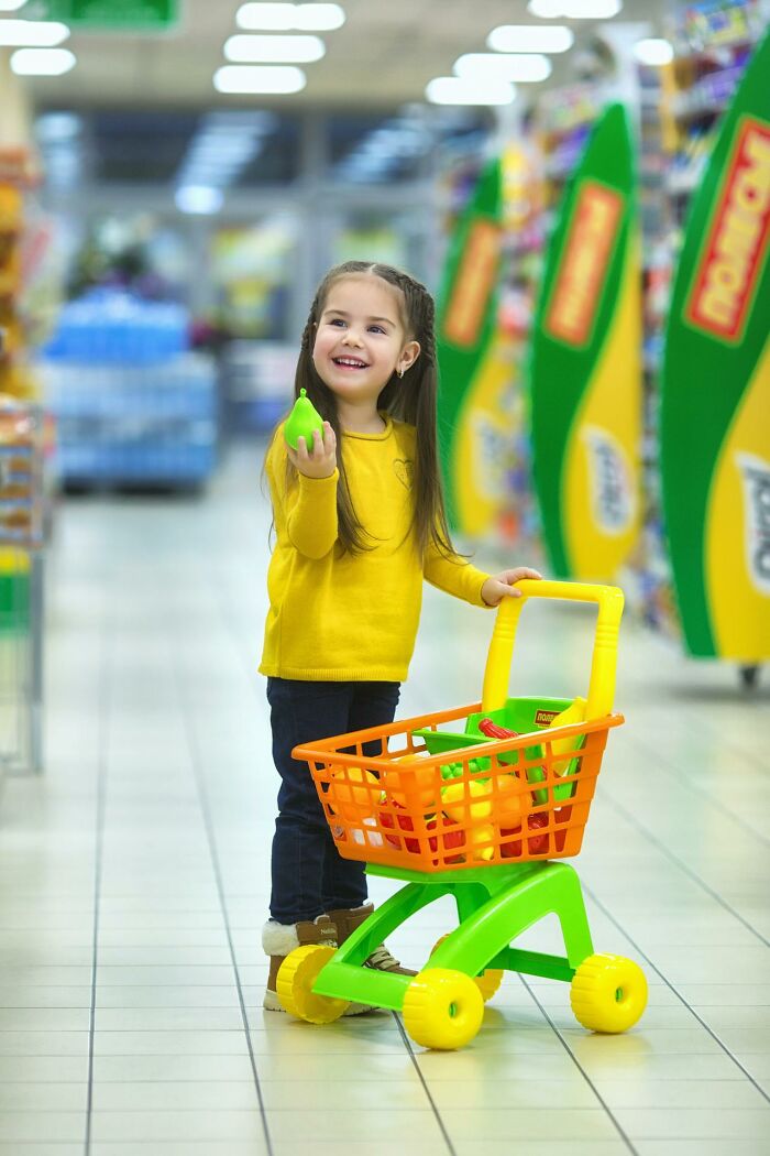 A child in a bright aisle with a colorful toy cart, symbolizing playful mom sanity hacks for parenting.
