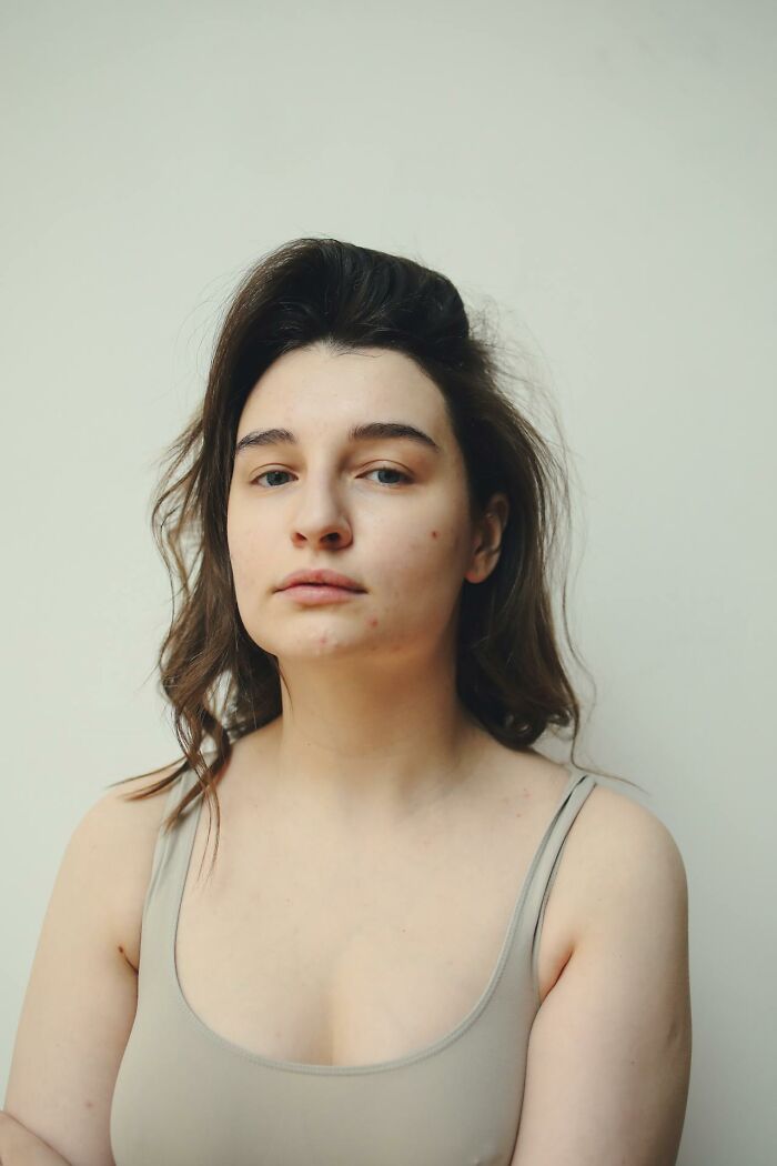 Woman in a beige top with a neutral expression, embodying common female insecurities that often confuse men.