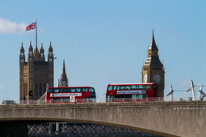 View of London landmarks with red double-decker buses, featuring clues to spot and type 30 countries hidden in the image.