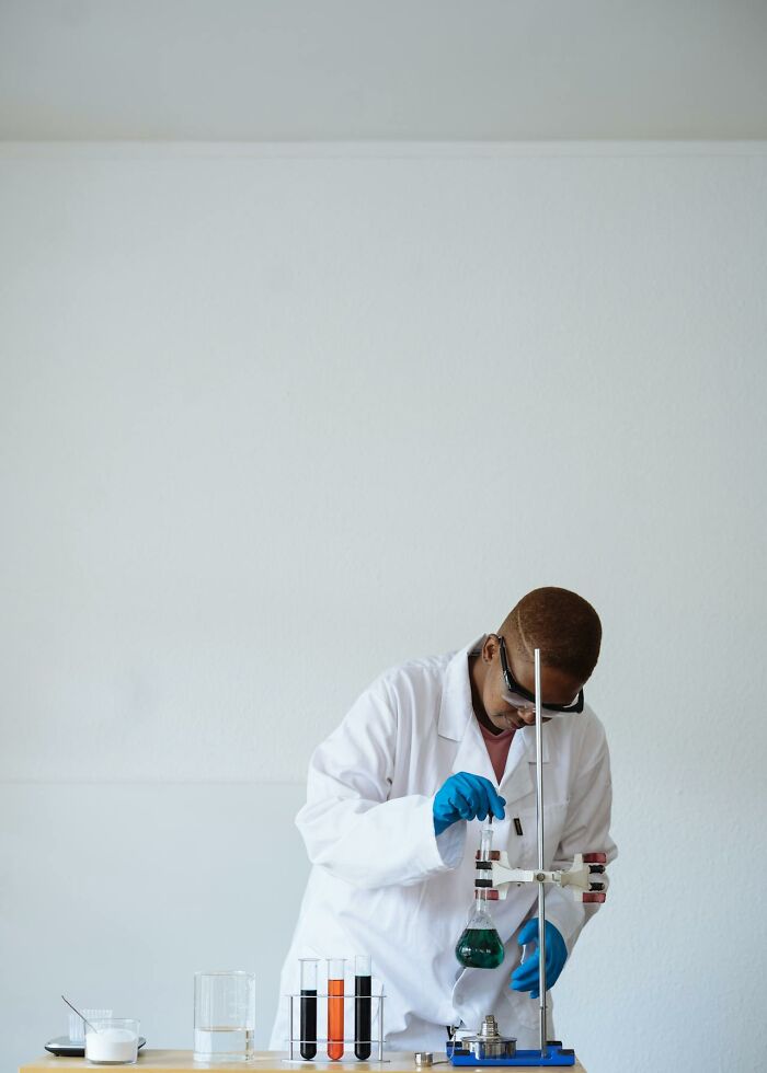 A scientist in a lab coat and goggles conducting an experiment, representing professional insights unknown to the public.