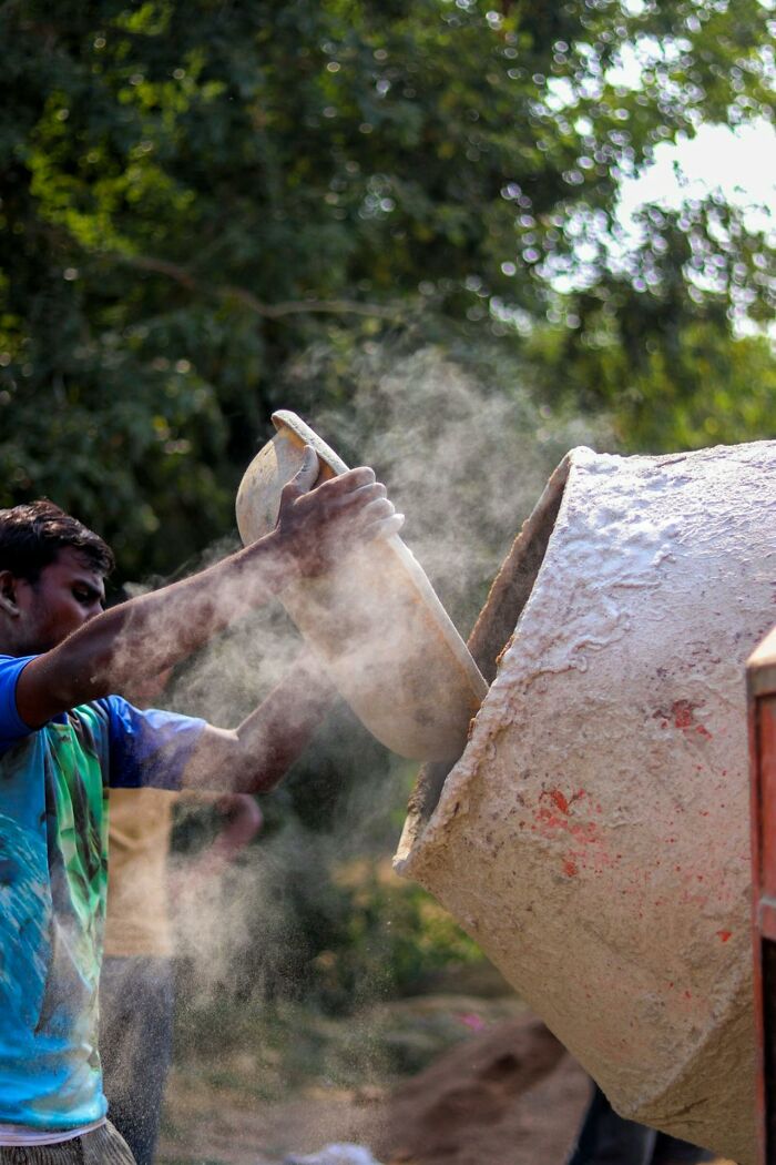 Worker in construction pouring cement into a mixer, highlighting a lesser-known aspect of the profession.