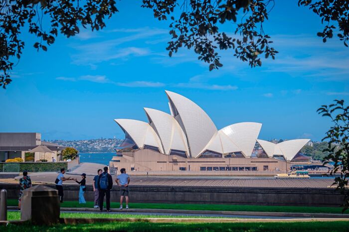 Americans abroad in Sydney, enjoying the Opera House view under a clear blue sky.