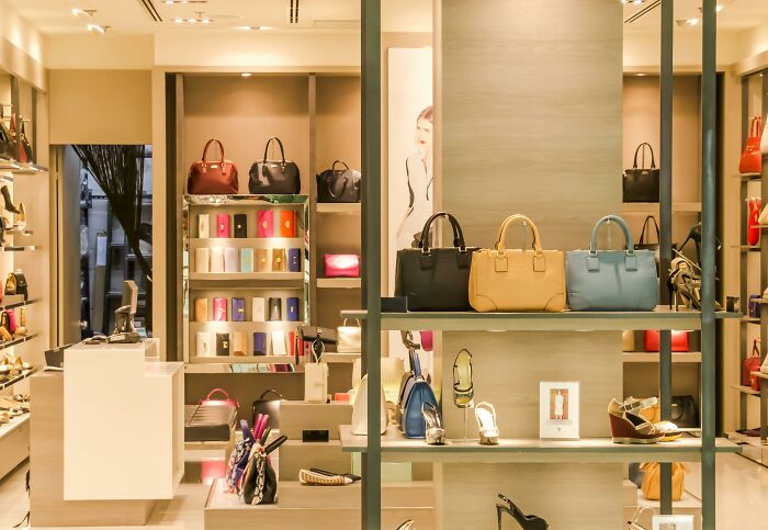 Luxury handbags and shoes displayed in a bright boutique, illustrating items bought after winning a lottery jackpot.