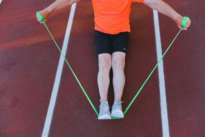 Person exercising with resistance band on track, illustrating how everyday items can be unexpectedly dangerous.