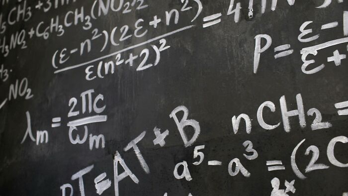 Chalkboard filled with complex mathematical equations and formulas, illustrating ladies share red pill stories concept.