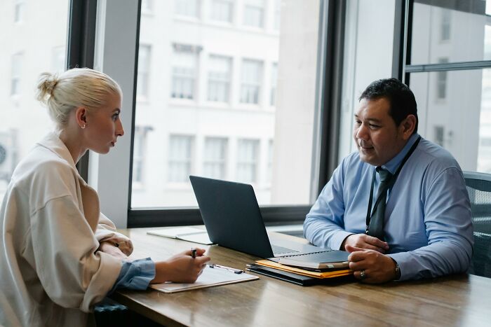 Two professionals in an office during a job interview, with a focus on spotting biggest red flags.