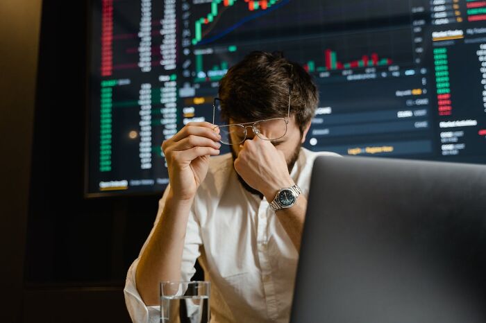 Man holding glasses and rubbing eyes, showing stress while reviewing data on screen, reflecting first responders' memorable calls.