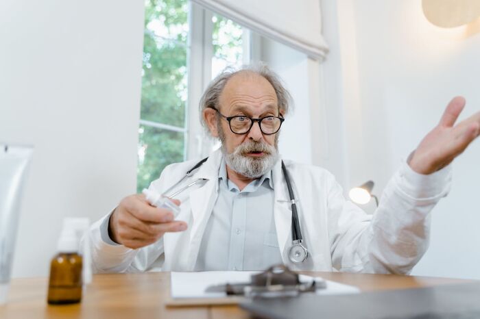 Doctor gesturing in office, highlighting gender disparity in pain meds prescription for women.